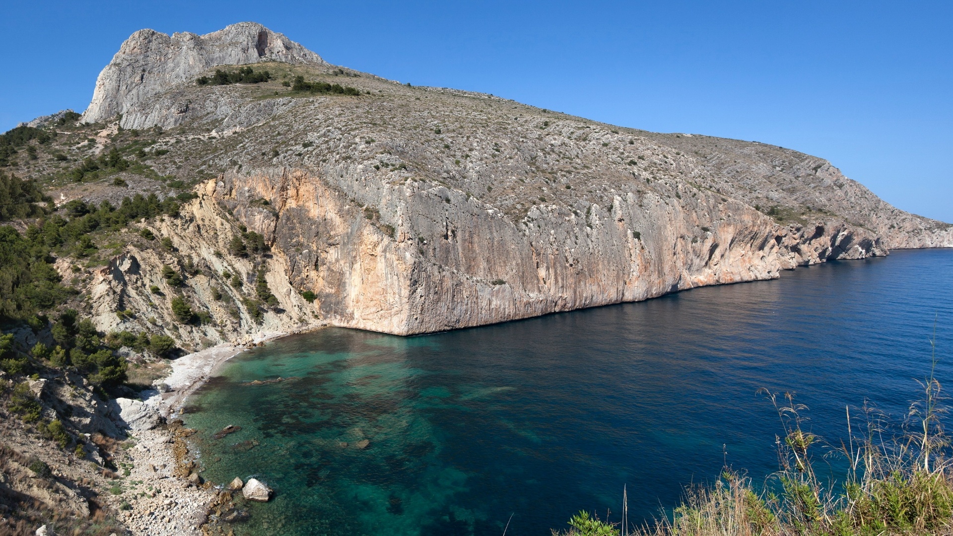 A paisagem de Calpe, na província espanhola de Alicante, é formada por estepes entre bruscos paredões costeiros. É um ambiente calmo e com grande apelo turístico dado pela bela vista do mar Mediterrâneo. É nesta paisagem (lá no topo, à esq.) que fica a Casa do Penhasco, desenhada pelos arquitetos do escritório Fran Silvestre - Diego Opazo/ Divulgação