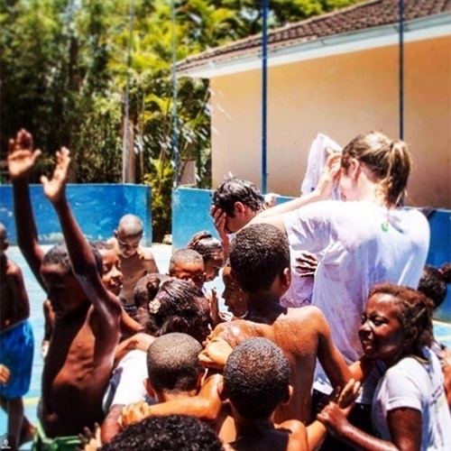 20.jan.2016 - Fernanda Gentil posta foto em que aparece com o marido, Matheus, tomando banho de mangueira rodeado de crianças - Reprodução/Instagram/gentilfernanda