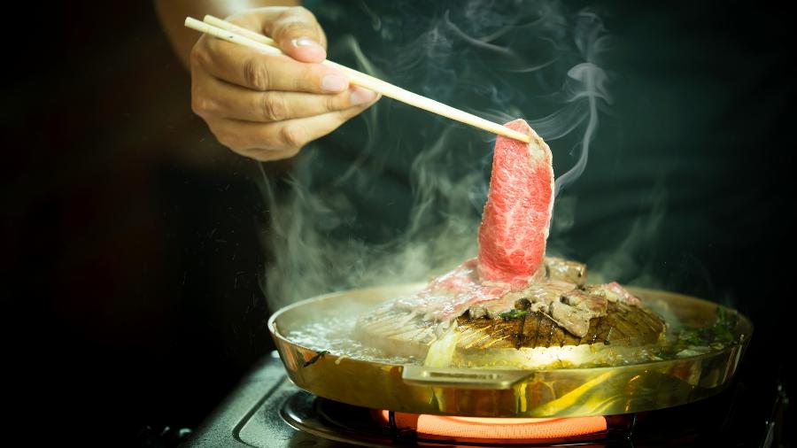 Fatia fina de carne leva "susto" na chapa colocada sobre fogão portátil - Getty Images/iStockphoto