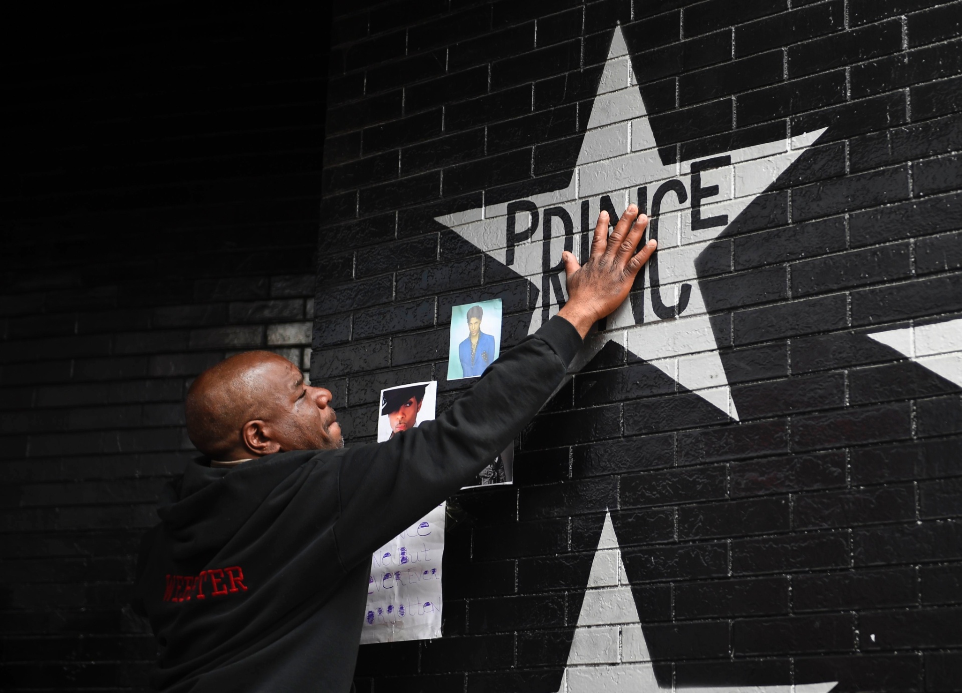 22.abr.2016 - Fã toca a estrela com o nome de Prince em Minneapolis, Minnesota - Craig Lassig/Reuters