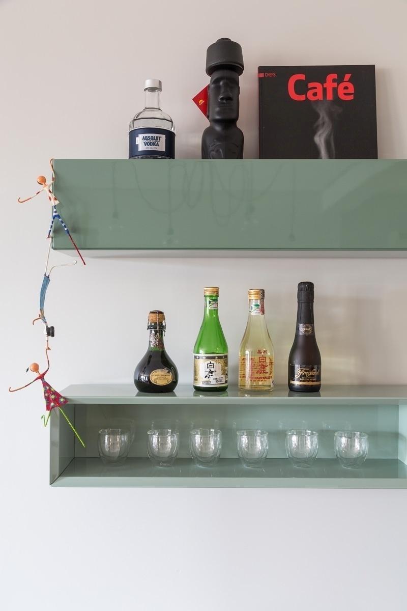 No cantinho da sala, o colorido está nos armários onde ficam as bebidas. Mais do que acomodar copos e garrafas, os módulos verdes criam um movimento interessante na parede - Evelyn Müller/Divulgação