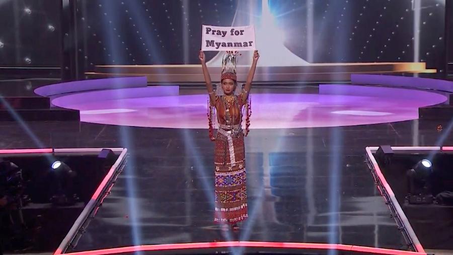 Representante de Mianmar no concurso Miss Universo, Thuzar Wint Lwin, segura cartaz com os dizeres "Orem por Mianmar" - MISS UNIVERSE/via REUTERS