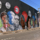 13.ago.2015 - Cinco grafiteiros trabalham na pintura de jornalistas e artistas da Globo em um muro da Marginal Tietê, na Barra Funda, bairro localizado na zona Oeste de São Paulo, próximo à sede da Record, a sua principal concorrente na TV aberta. O trabalho é uma homenagem dos profissionais aos 50 anos da emissora, completados em abril. - Reprodução/TV Globo