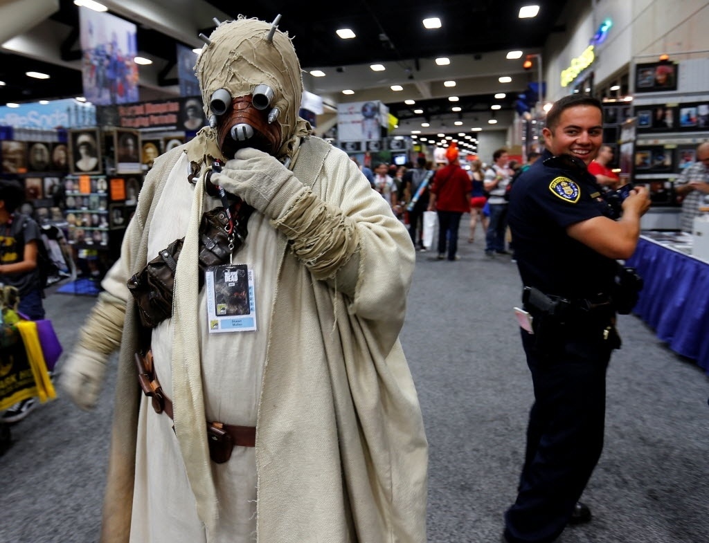 21.jul.2016 - Policial se esquiva de cosplayer de Tusken Raider, criatura do universo "Star Wars", no primeiro dia de San Diego Comic-Con 2016 - Reuters