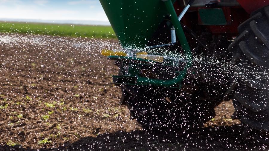Fertilizante sendo aplicado na terra por trator - Getty Images/iStockphoto