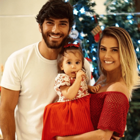 Usando um longo vermelho, Déborah Secco publicou uma foto com o marido e a filha prontos para celebrar o Natal - Reprodução/Instagram dedesecco