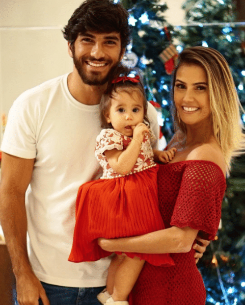Usando um longo vermelho, Déborah Secco publicou uma foto com o marido e a filha prontos para celebrar o Natal - Reprodução/Instagram dedesecco