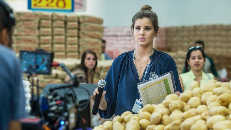 Luiza (Camila Queiroz) aceita a primeira oferta de emprego que aparece na sua vida depois da família perder toda a fortuna. A ex-milionária vira locutora de supermercado em "Pega Pega" - TV Globo/Maurício Fidalgo