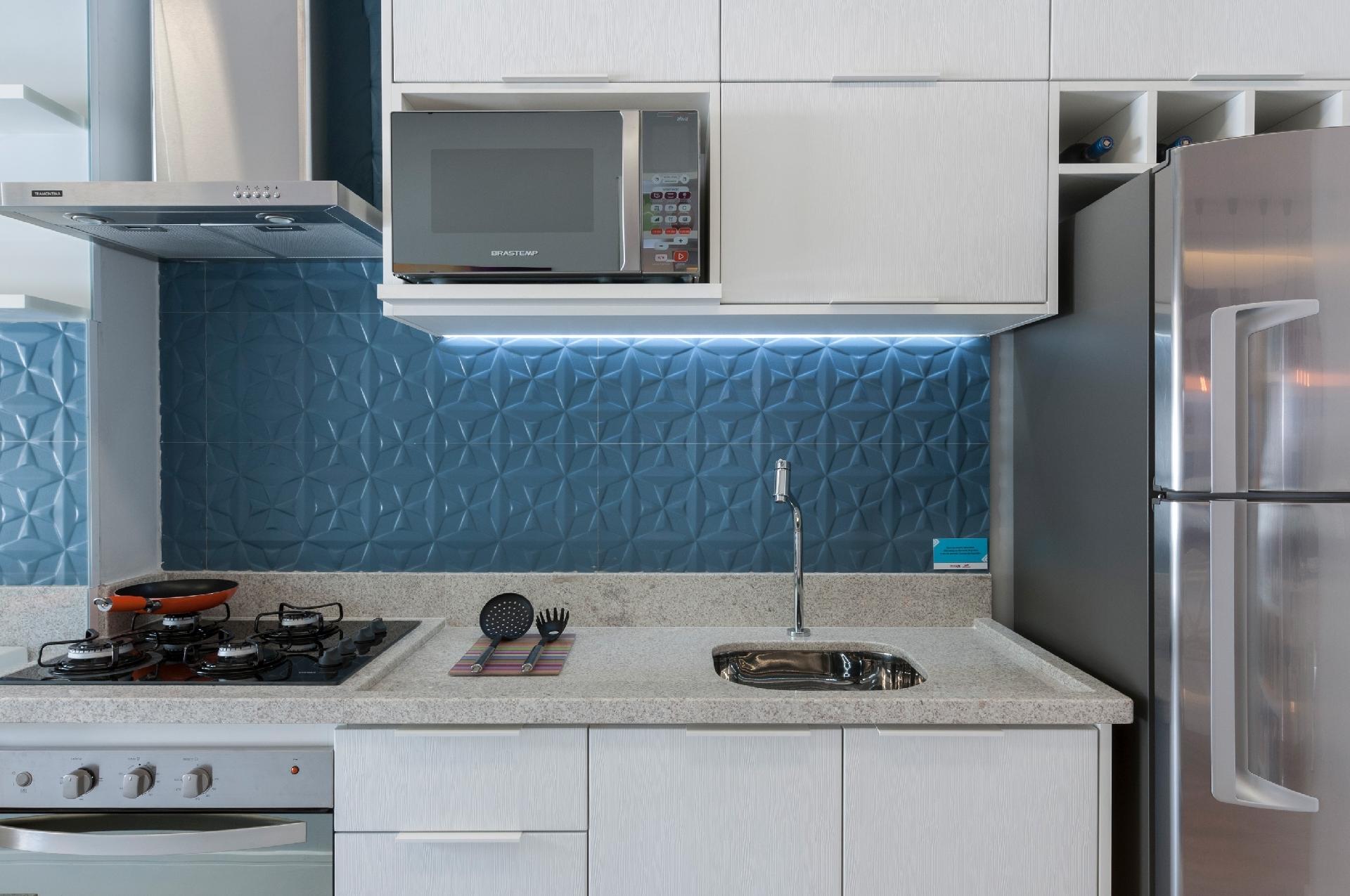 Com um recurso simples e pontual, a designer de interiores Adriana Fontana evidenciou as cerâmicas que decoram a parede da cozinha. Ela embutiu fitas de led na marcenaria - Raul Fonseca/Divulgação