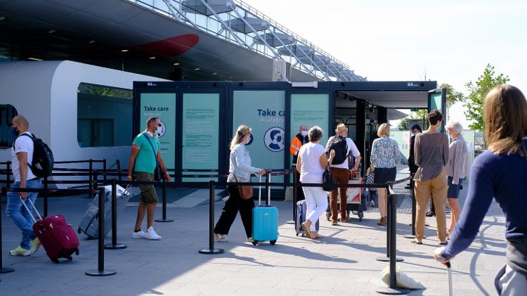 Pessoas passam por área de exames de covid-19 antes de entrarem no aeroporto de Bruxelas. Passageiros que estiverem com temperatura acima de 38 ºC não podem embarcar - Getty Images - Getty Images