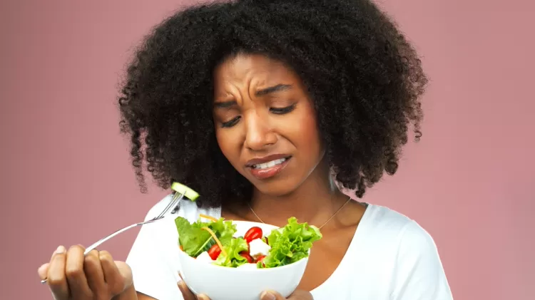 seletividade alimentar, mulher infeliz comendo salada - iStock - iStock