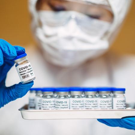 Coronavírus: profissional da saúde segura bandeja com candidatas à vacina da covid-19 - Getty Images