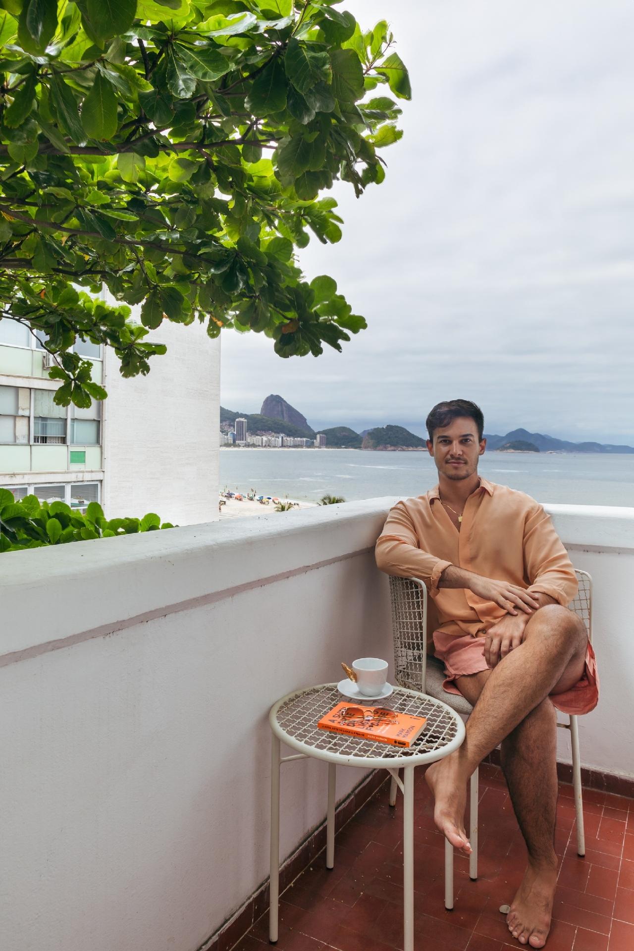 Na varanda, ele toma café e define o apartamento no estilo contemporâneo afetivo: vibrante, com suas coleções, feito aos poucos, levando em conta um reflexo de si mesmo como morador. - Luiza Schreier/Divulgação