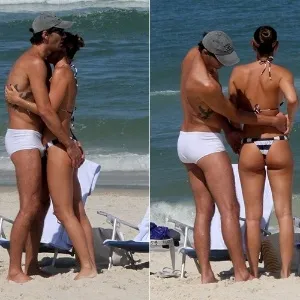 15.ago.2015 - Neste sábado de sol, Giba e Maria Luiza Daudt namoram em praia da Barra da Tijuca, no Rio de Janeiro. Entre abraços e beijinhos, ele dá um "confere" no bumbum da mulher - undefined