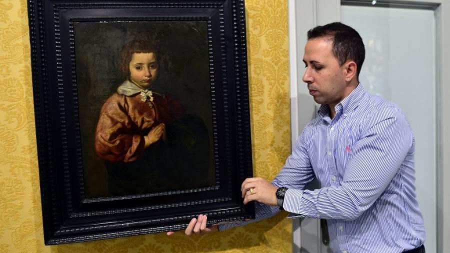 Funcionário da galeria Abalarte manuseia quadro de Diego Velázquez  - Gerard Julien/AFP Photo