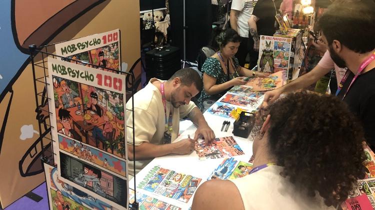 O quadrinista Paulo Moreira dá autógrafos para fãs na CCXP 24