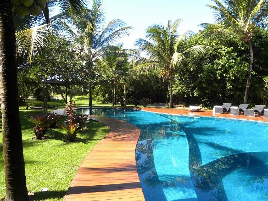 Neste jardim com 11 mil m² em Trancoso, na Bahia, o paisagista Marcelo Faisal fez uso de plantas comuns na restinga como cajueiros (Anacardium occidentale) e licuris (Syagrus coronata), além de algumas outras espécies como coqueiros (Cocos nucifera L.) e bromélias que enfeitam a área em redor da piscina - Divulgação