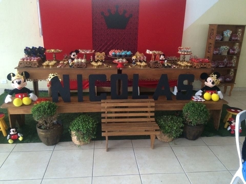 Uma mesa de madeira com acabamento trabalhado foi planejada pela Aluguel de Decoração Provençal (www.facebook.com/marciafenelonsza) para receber o bolo e os docinhos. Logo abaixo, um banco do mesmo tamanho para apoiar os personagens e o letreiro - Divulgação
