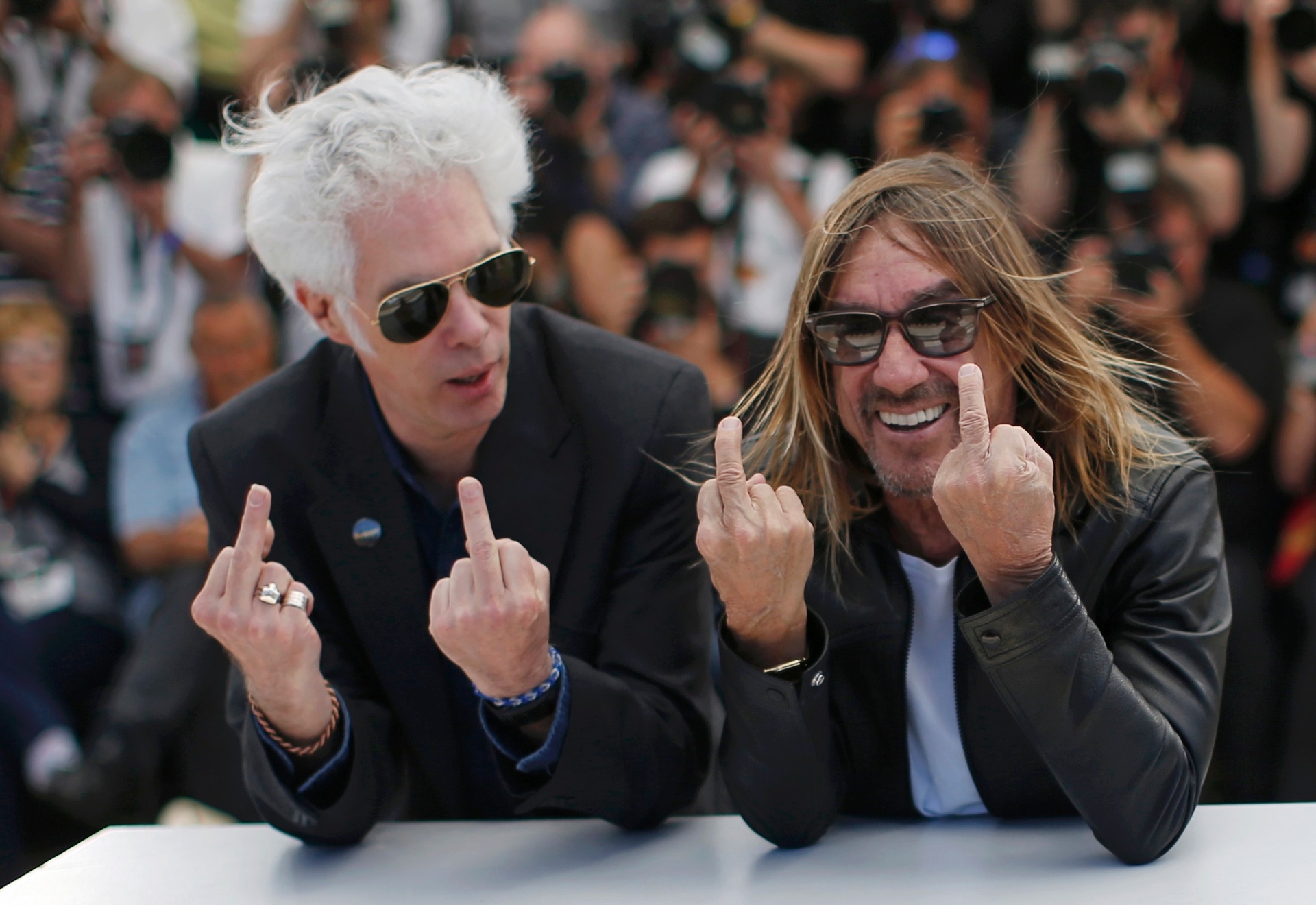19.mai.2016 - Diretor Jim Jarmusch e cantor Iggy Pop mostram o dedo do meio no tapete vermelho de Cannes - REUTERS/Eric Gaillard