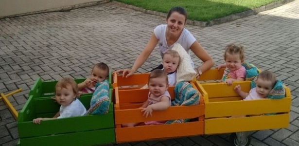 Os bebês e a professora Fabíola no trenzinho já pintado - Divulgação