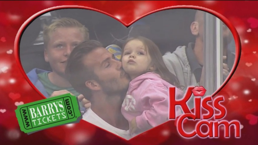 28.mai.2013 - David Beckham beija a filha Harper ao serem flagrados pela câmera do beijo em jogo de hóquei em Los Angeles