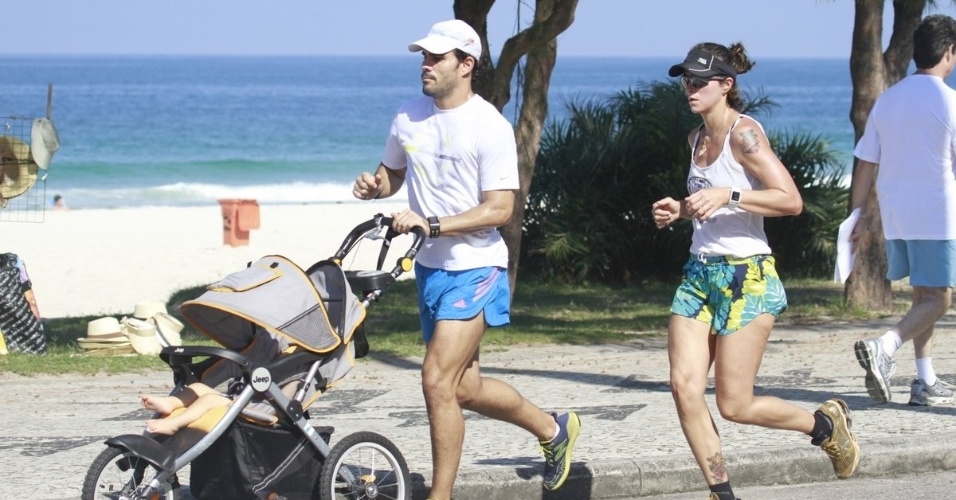 7.jun.2013 - Juliano Cazarré corre com a mulher na orla da Barra