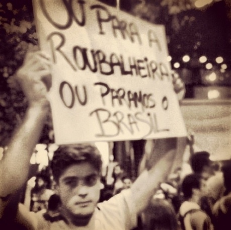 17.jun.2013 - O modelo Evandro Soldati leva cartaz durante manifestação no Rio de Janeiro