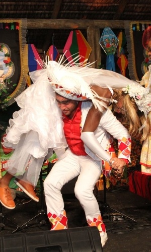 17.jun.2013 - O noivo Diogo Nogueira carrega a noiva, o cantor Mumuzinho, após a cerimônia de casamento no Arraiá da Marrom, no Rio
