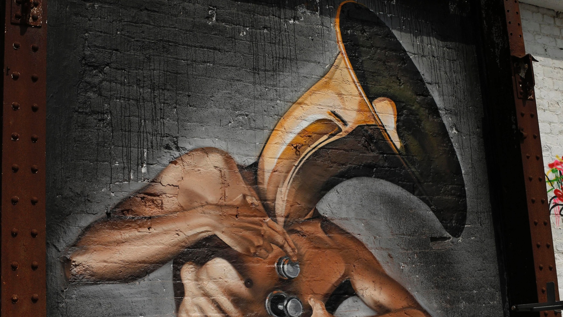 18.junho.2013 - Grafite que mostra homem sendo o próprio trombone é um dos trabalhos do festival de arte de rua "Sand, Sea and Spray" - REUTERS/Phil Noble