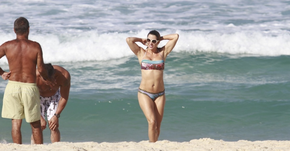 19.jun.2013 - Joana Prado se refresca na praia da Barra da Tijuca, no Rio de Janeiro. A apresentadora está acompanhada do marido, o lutador Vitor Belfort