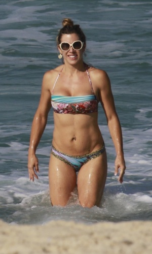 cv19.jun.2013 - Joana Prado se refresca na praia da Barra da Tijuca, no Rio de Janeiro. A apresentadora está acompanhada do marido, o lutador Vitor Belfort
