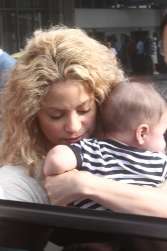 20.jun.2013 - A cantora colombiana Shakira desembarca no aeroporto internacional do Rio de Janeiro com o filho Milan. A cantora pega o bebê antes de entrar no carro, cercada por seguranças. Ela veio encontrar o namorado, o jogador da seleção espanhola Piqué