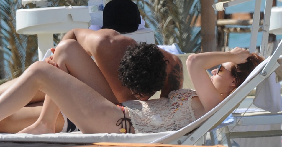 12.jun.2013 - O jogador Alexandre Pato beija a barriga da namorada, Barbara Berlusconi, durante dia de praia na Sardenha. O casal está junto desde março de 2011. O casal está junto desde março de 2011