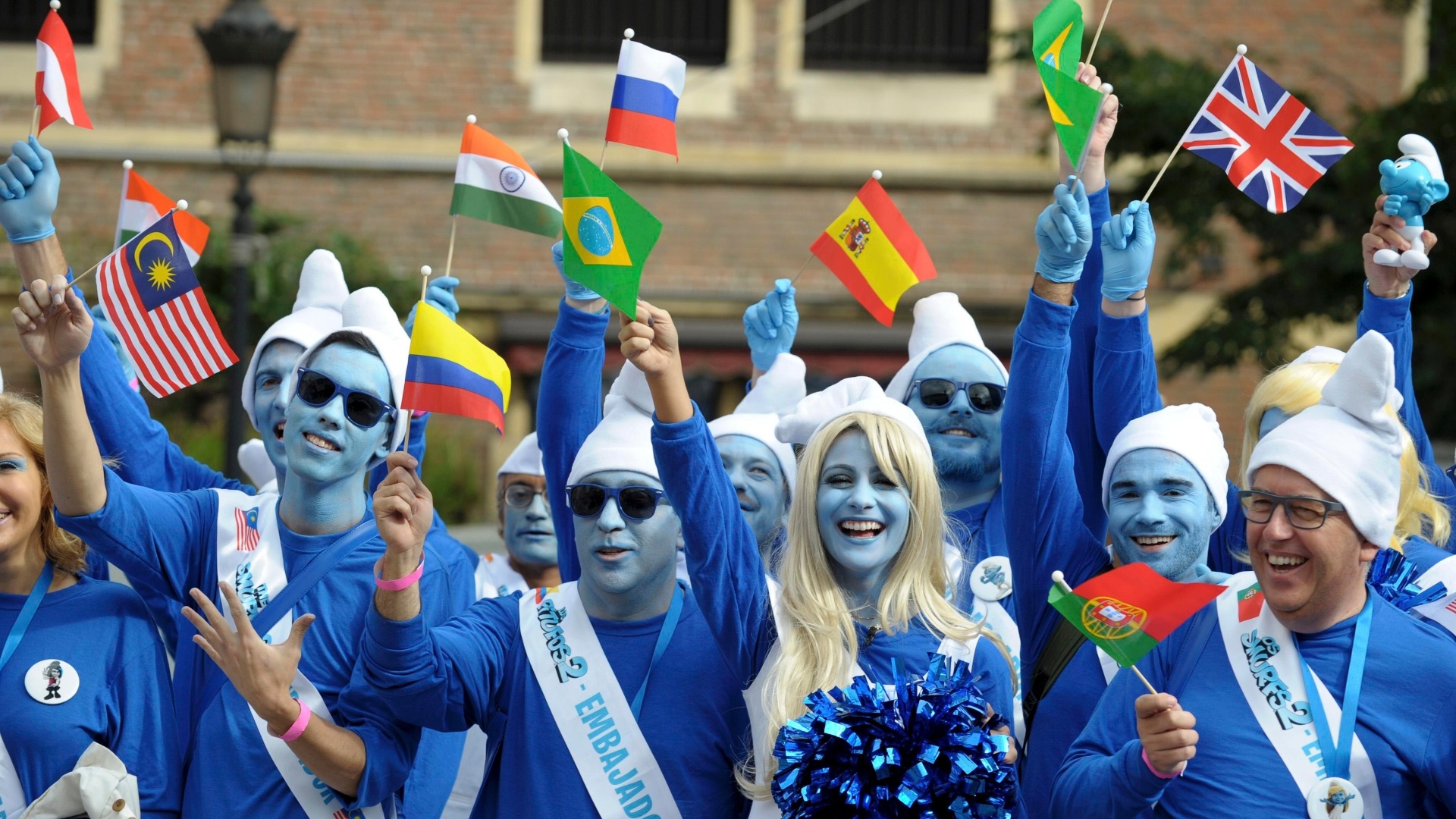22.jun.2013 - Embaixadores Smurfs celebram o aniversário de seu criador, Peyo, e também o Dia Global dos Smurfs, em Bruxelas, Bélgica, com bandeiras de diversos países - Laurent Dubrule / Reuters