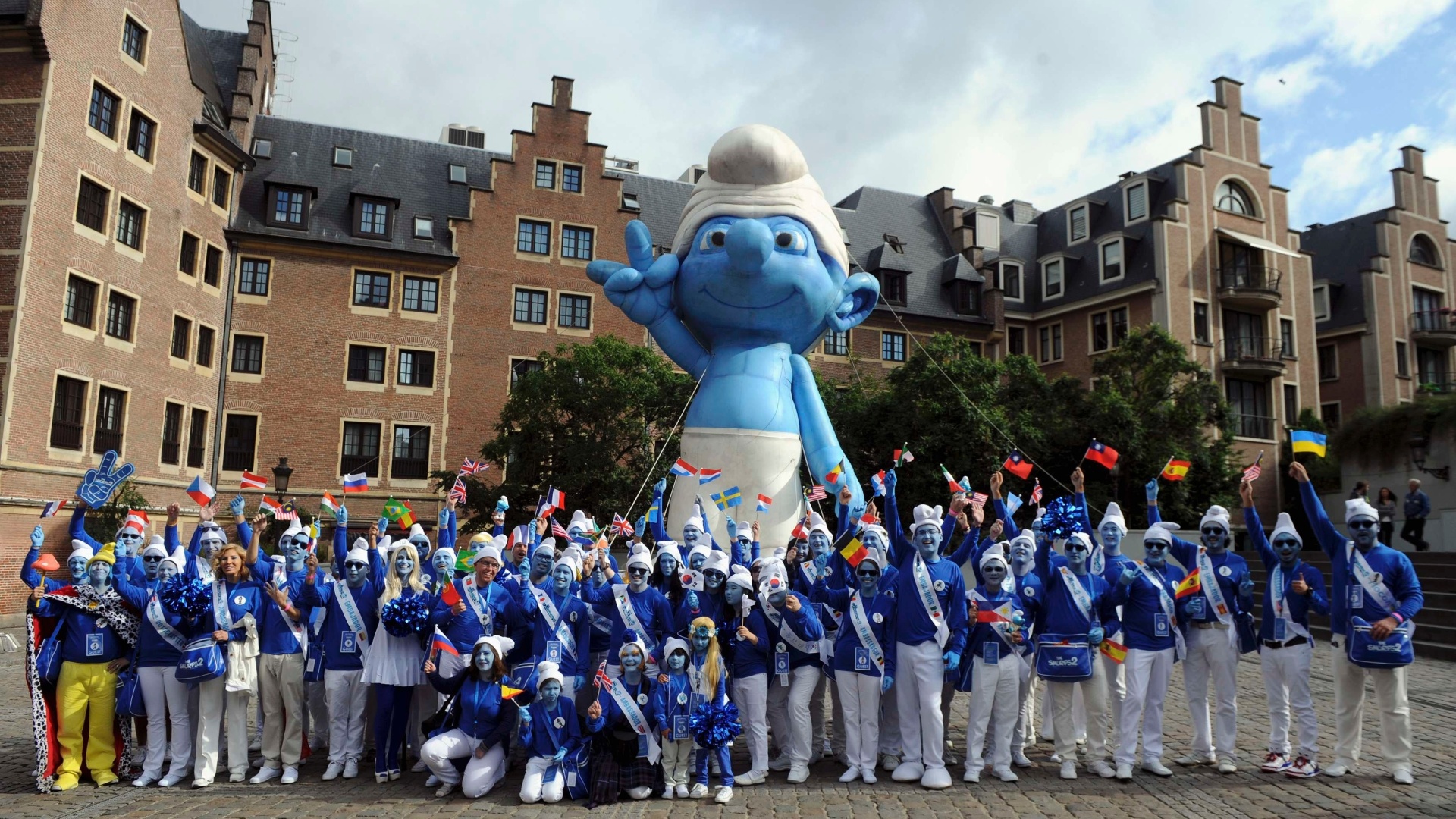 22.jun.2013 - Embaixadores Smurfs posam junto a um Smurf inflável gigante durante a celebração do aniversário de seu criador, Peyo, e também o Dia Global dos Smurfs, em Bruxelas, Bélgica - Laurent Dubrule / Reuters
