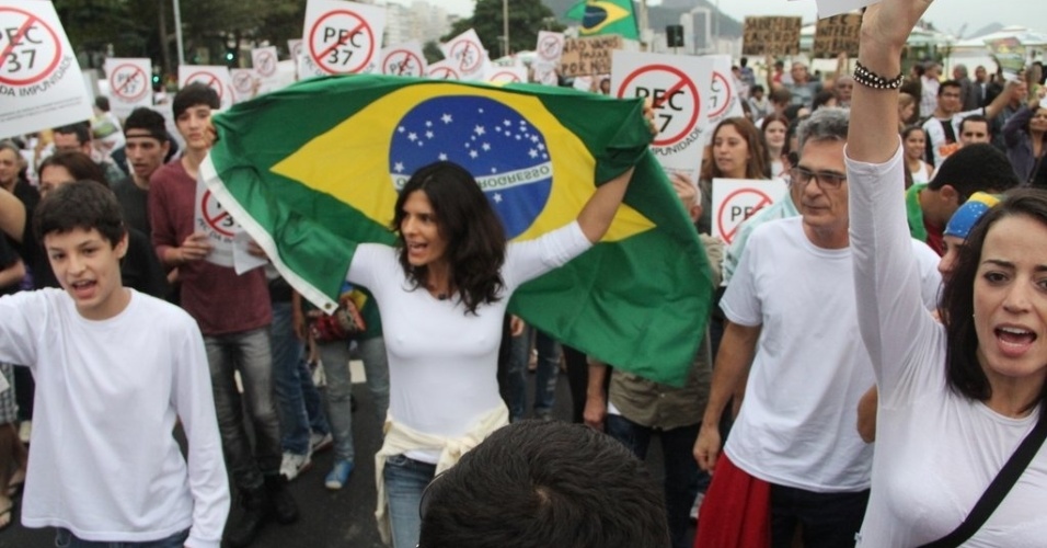 23.jun.2013 - Helena Ranaldi leva a bandeira do Brasil durante manifestação contra a PEC 37 na orla de Copacabana, no Rio de Janeiro