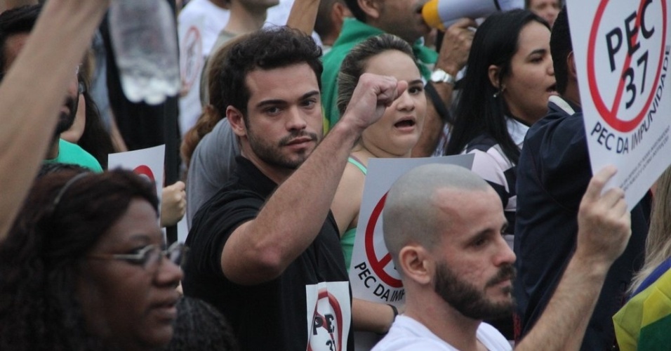 23.jun.2013 - O ator Sidney Sampaio leva cartaz contra a PEC 37 durante manifestação na orla de Copacabana, no Rio de Janeiro