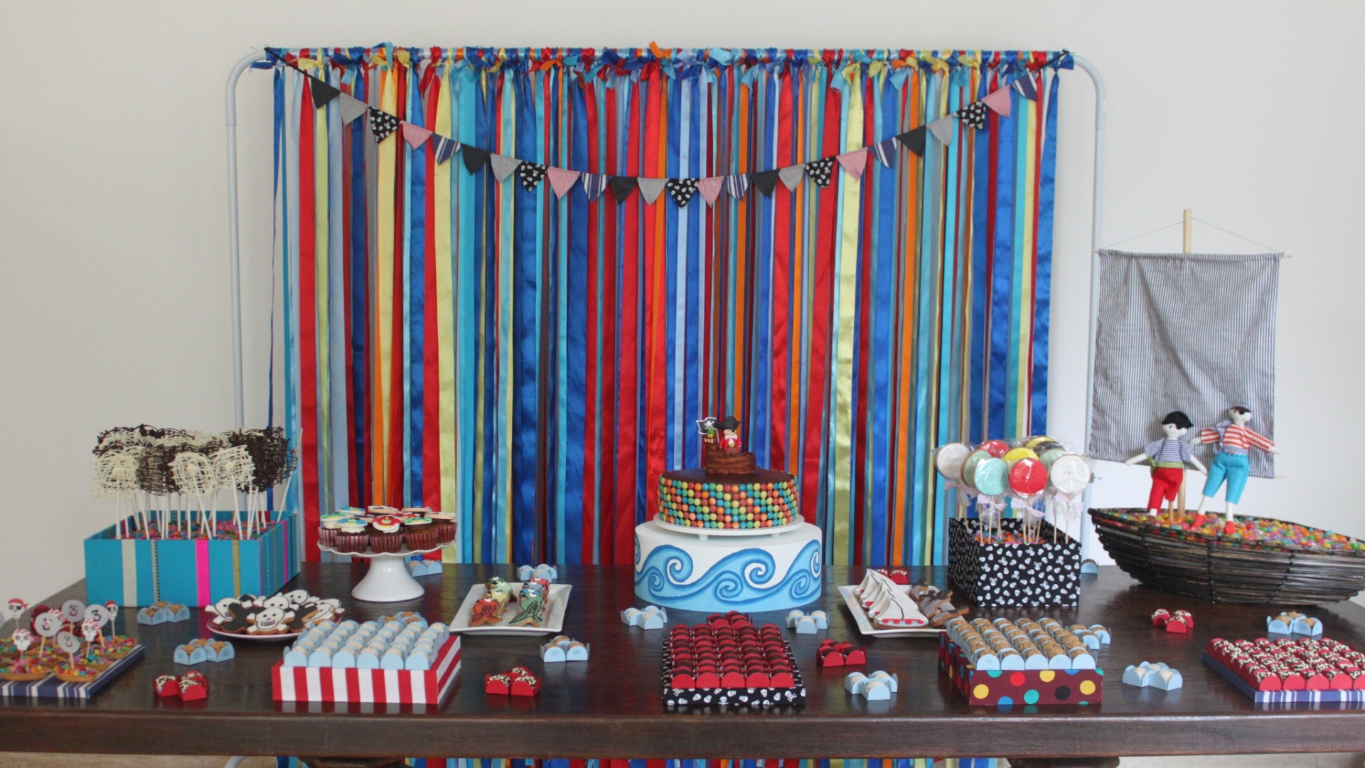 A festa realizada por Tammy Montagna (www.tammymontagna.com) tem o tema Pirata. A cortina que cobre a janela do salão de festas foi feita exclusivamente para a comemoração, com uma estrutura de ferro onde foram presas fitas coloridas de cetim - Divulgação