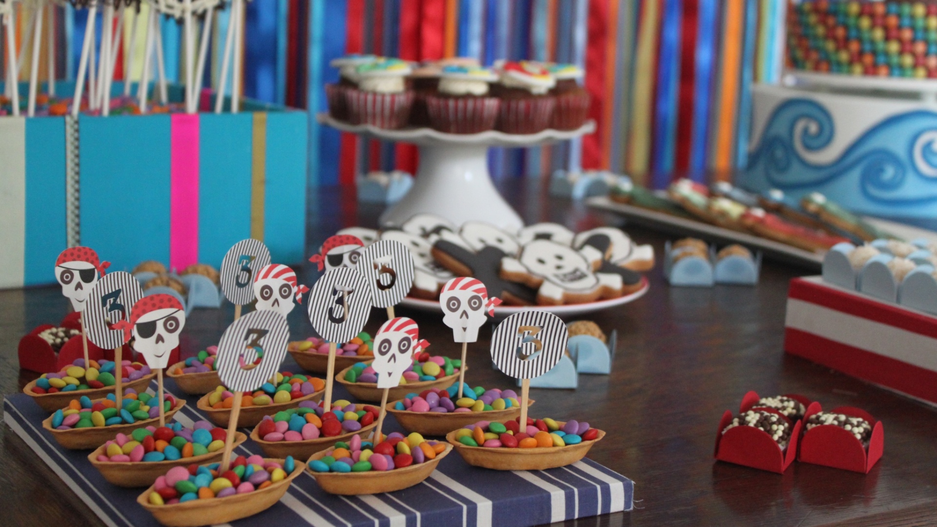 Barquinhos comestíveis foram recheados de confetes e decorados com pequenas velas: algumas com uma caveirinha e outras com o número três, a idade da criança anfitriã - Divulgação