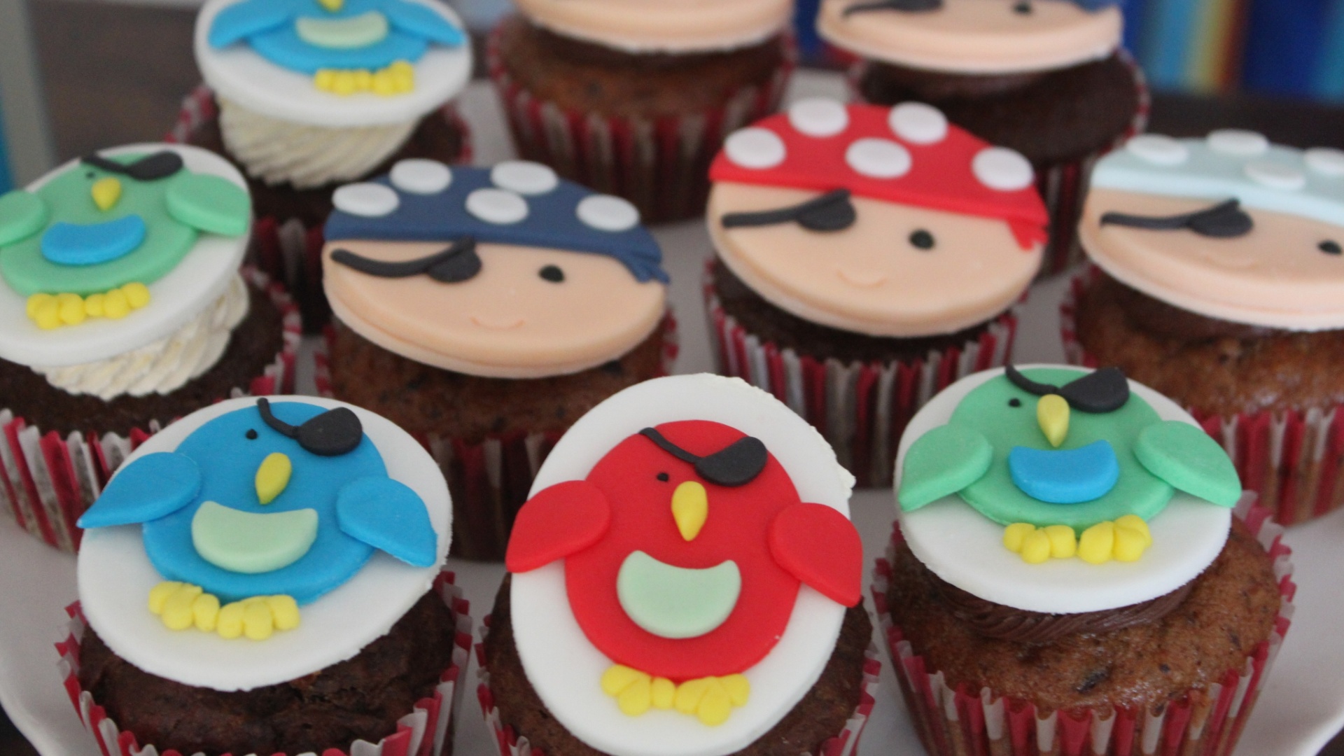 Entre os docinhos da festa Pirata, feita por Tammy Montagna, estão cupcakes cobertos por uma plaquinha de pasta americana. Tammy criou diferentes piratas e papagaios para enfeitar os bolinhos - Divulgação