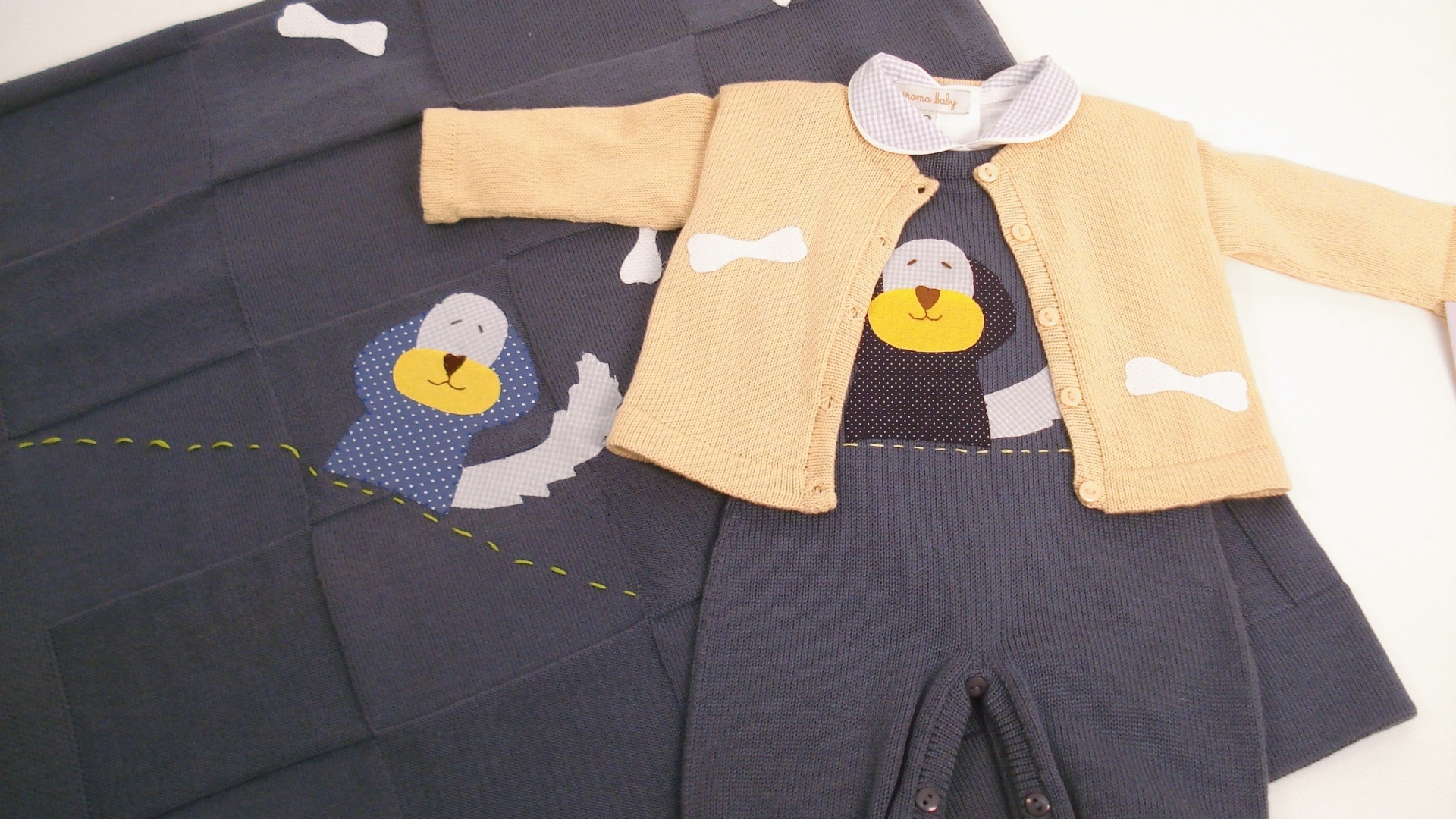 Conjunto de salopete e casaco, body de gola com a manta bordada. Motivo de cachorrinho com desenhos de ossos aplicados à mão na técnica patchwork. Tamanho: P. Da Iroma Baby (www.enxovaldebebe.com.br). R$ 407,90. Preço consultado em junho de 2013. Sujeito a alterações - Divulgação