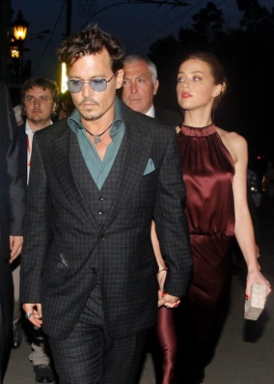O ator Johnny Depp chega de mãos dadas com a atriz Amber Heard em um restaurante em Moscou, na Rússia