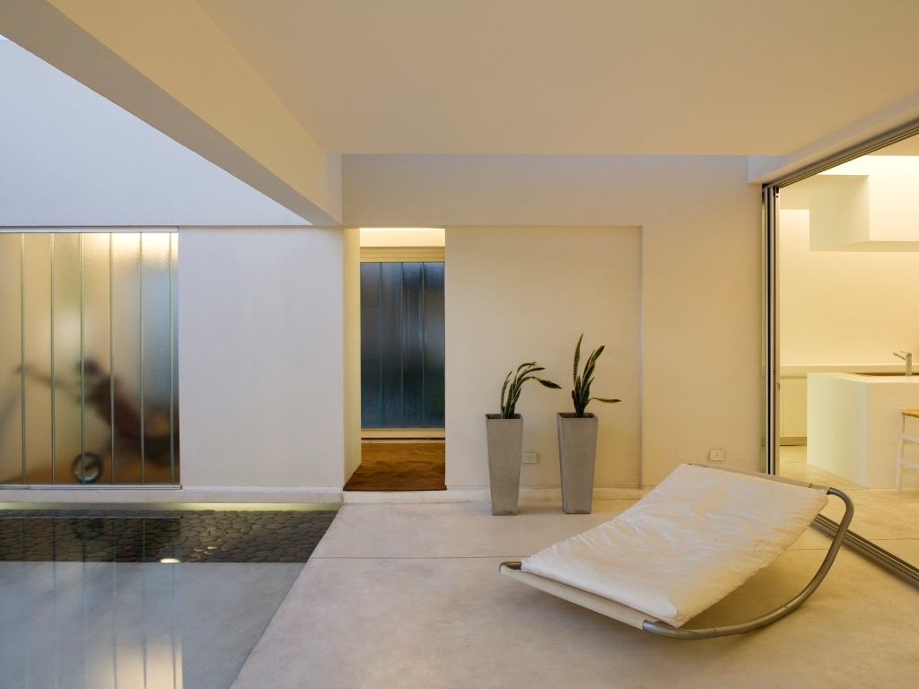 A chamada galeria da Casa Caja - ou Patio - volta-se para o espelho d'água. Esse é o único ponto onde a arquitetura deixa transparecer elementos estruturais em concreto armado: vigas e pilares. Todo o resto da residência foi executado em alvenaria autoportante, possível graças à simplicidade do desenho que o conceito aberto estruturado pelos arquitetos Juan Germán Guardati, Román Renzi e Virginia Kahanoff exigia. A casa de linhas retas fica na província argentina de Santa Fe - Leonardo Finotti/ UOL