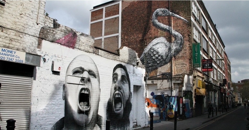 O polêmico grafite com dois homens gritando - um nacionalista britânico e um radical islâmico - foi apagado em outubro do ano passado. Ele foi criado pelo artista de Londres Ben Slow, que já exibiu trabalhos nos EUA, França e Espanha. Logo atrás, se vê a obra "O flamingo", do artista belga residente na capital britânica que usa o pseudônimo de ROA - BBC