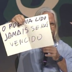 6.jul.2013 - O poeta cuiabano Nicolas Behr diverte público da Flip com cartazes de "protesto" que valorizam a poesia - Reprodução/YouTube