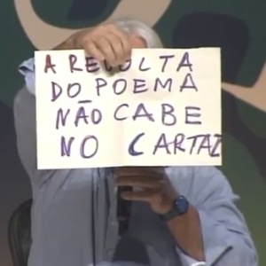6.jul.2013 - O poeta cuiabano Nicolas Behr diverte público da Flip com cartazes de "protesto" que valorizam a poesia - Reprodução/YouTube