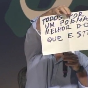 6.jul.2013 - O poeta cuiabano Nicolas Behr diverte público da Flip com cartazes de "protesto" que valorizam a poesia - Reprodução/YouTube