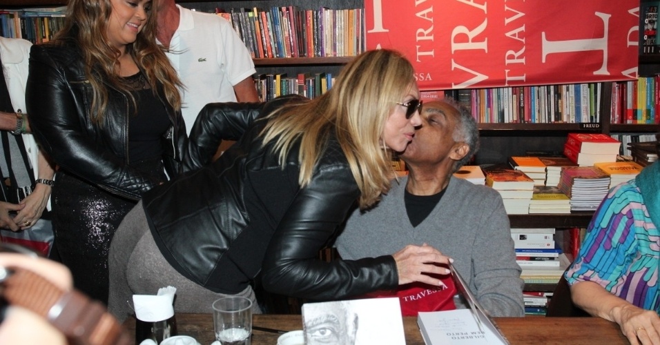 8.jul.2013 - A atriz Arlete Salles ganha beijo de Gilberto Gil durante lançamento da biografia do cantor, "Gilberto Bem Perto", em livraria do Rio