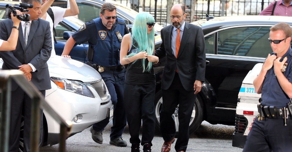 8.jul.2013 - Amanda Bynes chega a um tribunal de Nova York usando uma peruca azul, óculos escuros, regata, calça de moletom e regata. A atriz vai responder às acusações de conduta imprudente, posse de drogas e adulteração de evidências
