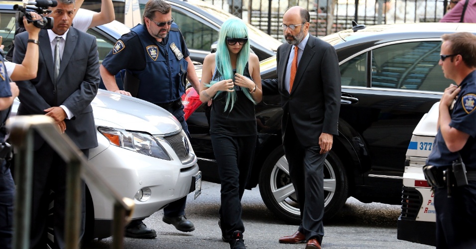 8.jul.2013 - Amanda Bynes chega a um tribunal de Nova York usando uma peruca azul, óculos escuros, regata, calça de moletom e regata. A atriz vai responder às acusações de conduta imprudente, posse de drogas e adulteração de evidências